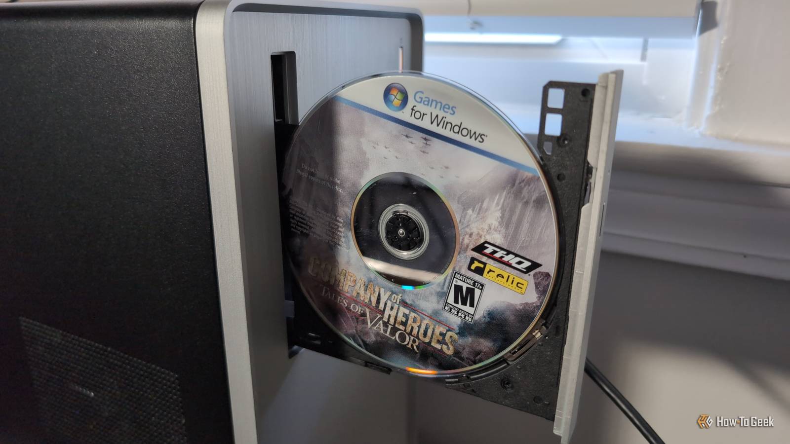 /de/images/a-cd-rom-in-an-open-pc-disc-drive-with-a-label-on-the-cd-reading-games-for-windows-and-the-title-of-the-game-company-of-heroes-tales-of-valor.jpg