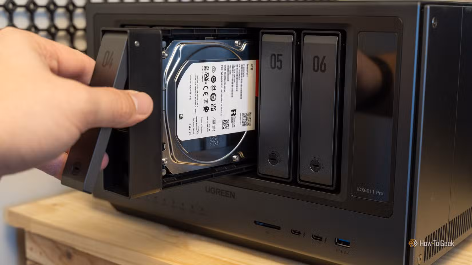 /images/a-hand-sliding-a-drive-tray-with-a-seagate-ironwolf-4tb-hard-drive-into-the-ugreen-idx6011-pro-nas.jpg